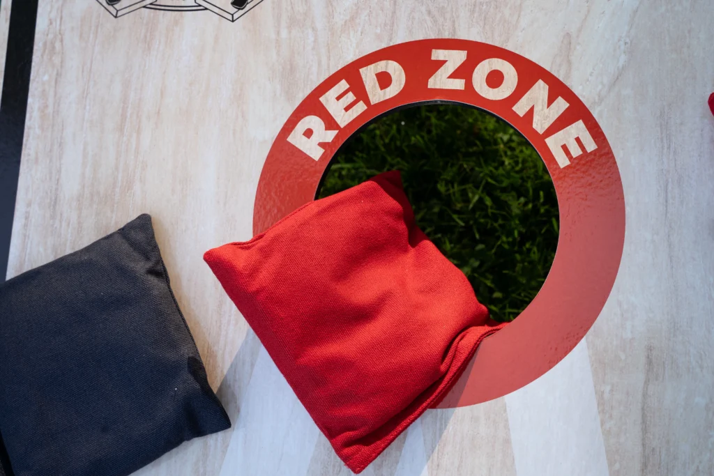Cornhole Pro Set met rode en navy werpzakken op het gras