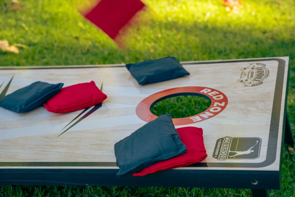 Cornhole Pro Set met rode en navy werpzakken op het gras