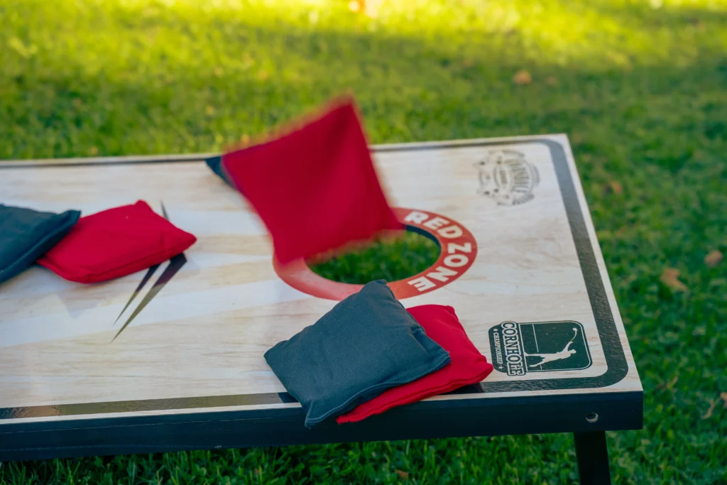 Cornhole Pro Set met rode en navy werpzakken op het gras